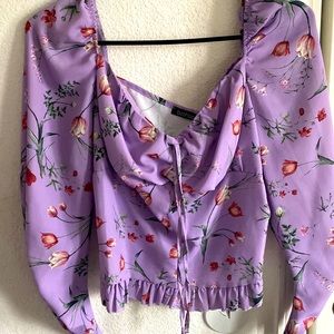 Light purple flowing blouse with long sleeves, & pink peddle roses.